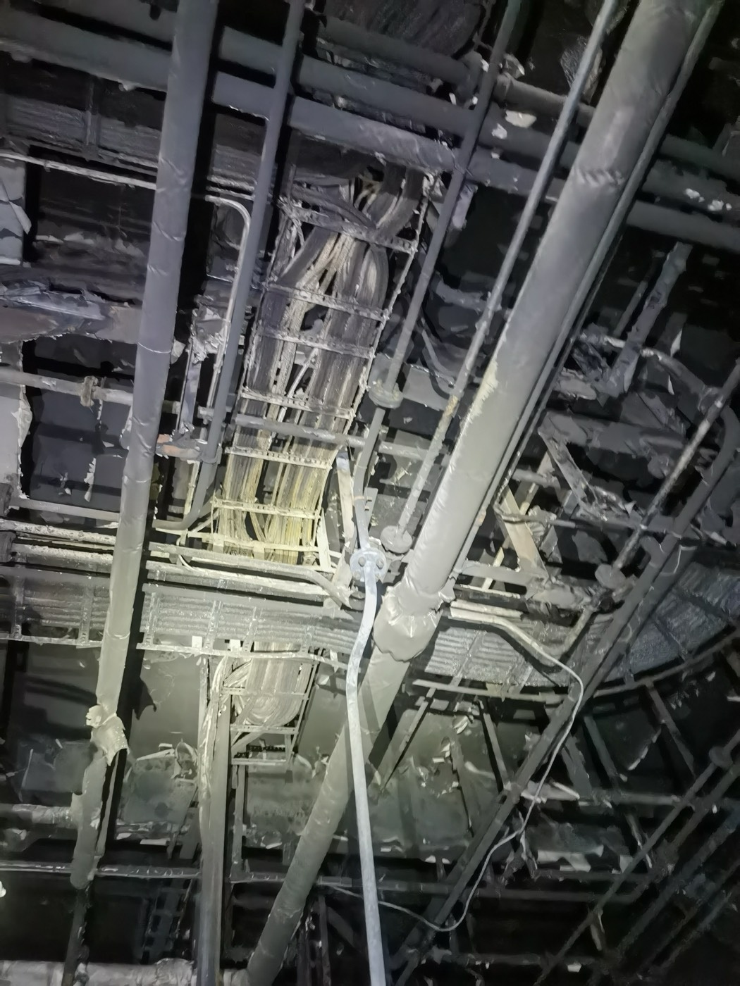 Charred cable trays and pipework above the engine room after the fire