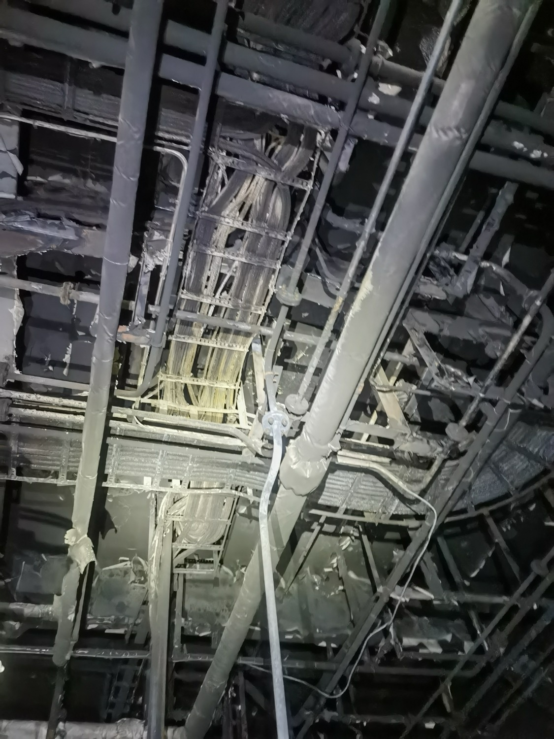 Charred overhead cable trays and pipework